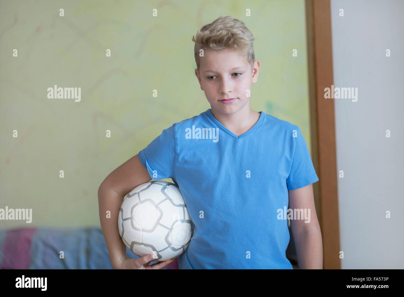 Jungen Fußball unter dem Arm hält und blickte, Freiburg Im Breisgau, Baden-Württemberg, Deutschland Stockfoto