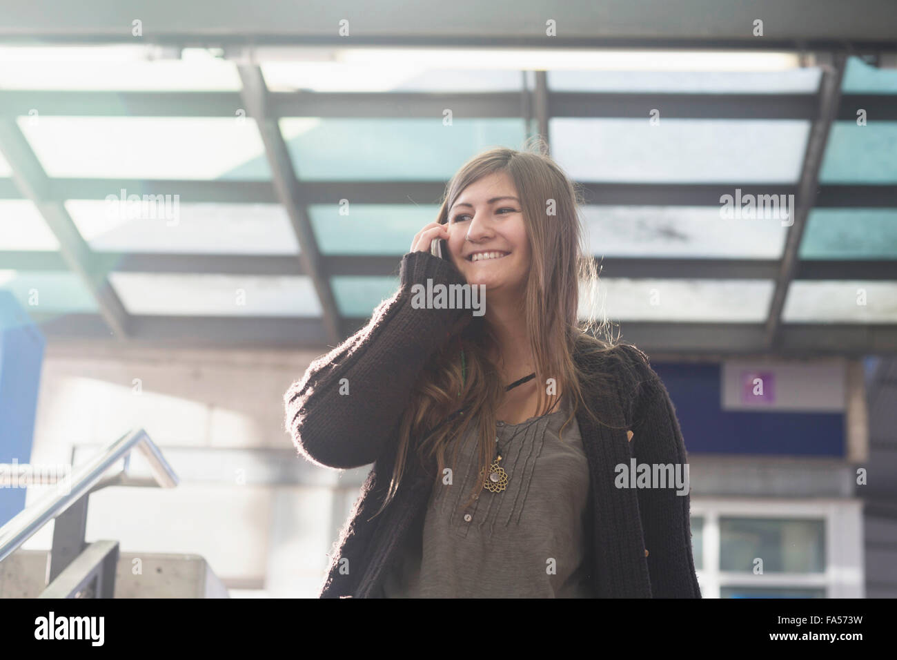 Junge Frau am Handy sprechen und Lächeln, Freiburg Im Breisgau, Baden-Württemberg, Deutschland Stockfoto