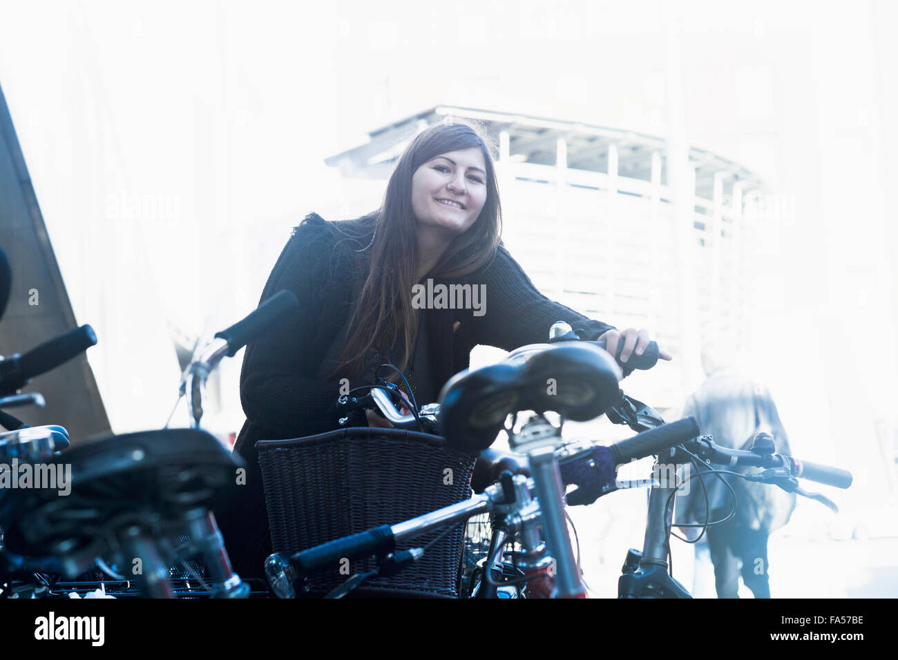 Junge Frau mit dem Fahrrad auf Parkplatz, Freiburg Im Breisgau, Baden-Württemberg, Deutschland Stockfoto