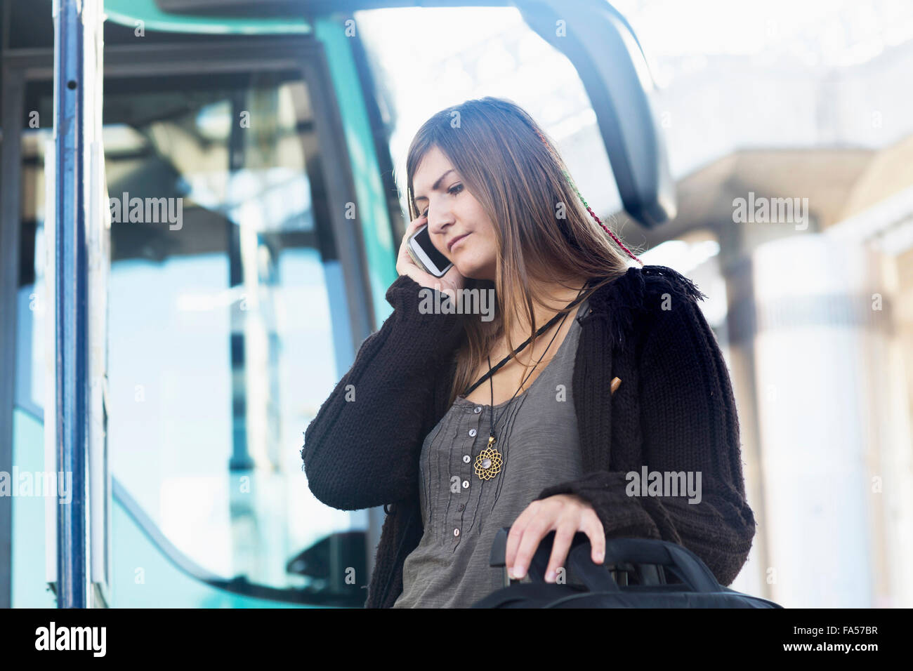 Junge Frau am Handy sprechen und stand vor Bus, Freiburg Im Breisgau, Baden-Württemberg, Deutschland Stockfoto