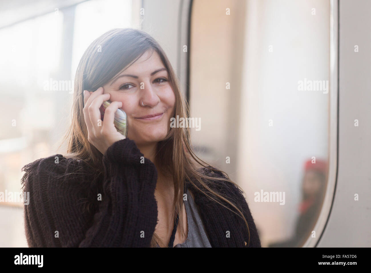Porträt einer jungen Frau telefonieren mit Handy vor einen Zug, Freiburg Im Breisgau, Baden-Württemberg, Deutschland Stockfoto
