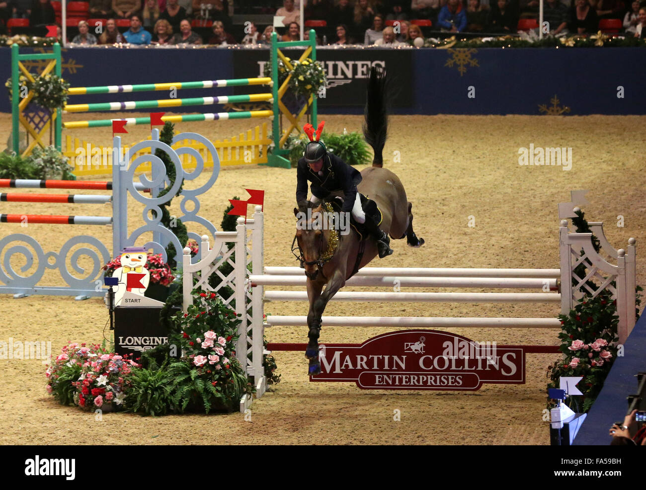 London, UK. 21. Dezember 2015. John Whitaker von Großbritannien konkurriert während das Paar Relais Springprüfung der London International Horse Show 2015 in Olympia, London, Großbritannien am 21. Dezember 2015. John Whitaker und Robert Whitaker von Großbritannien Rang den dritten. Bildnachweis: Han Yan/Xinhua/Alamy Live-Nachrichten Stockfoto