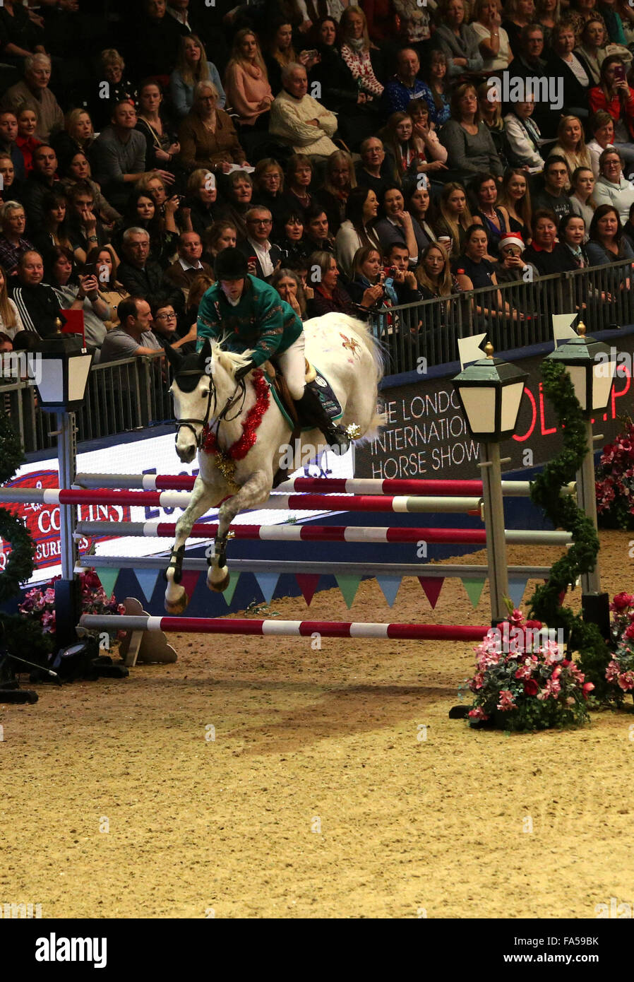 London, UK. 21. Dezember 2015. Robert Whitaker von Großbritannien konkurriert während das Paar Relais Springprüfung der London International Horse Show 2015 in Olympia, London, Großbritannien am 21. Dezember 2015. John Whitaker und Robert Whitaker von Großbritannien Rang den dritten. Bildnachweis: Han Yan/Xinhua/Alamy Live-Nachrichten Stockfoto