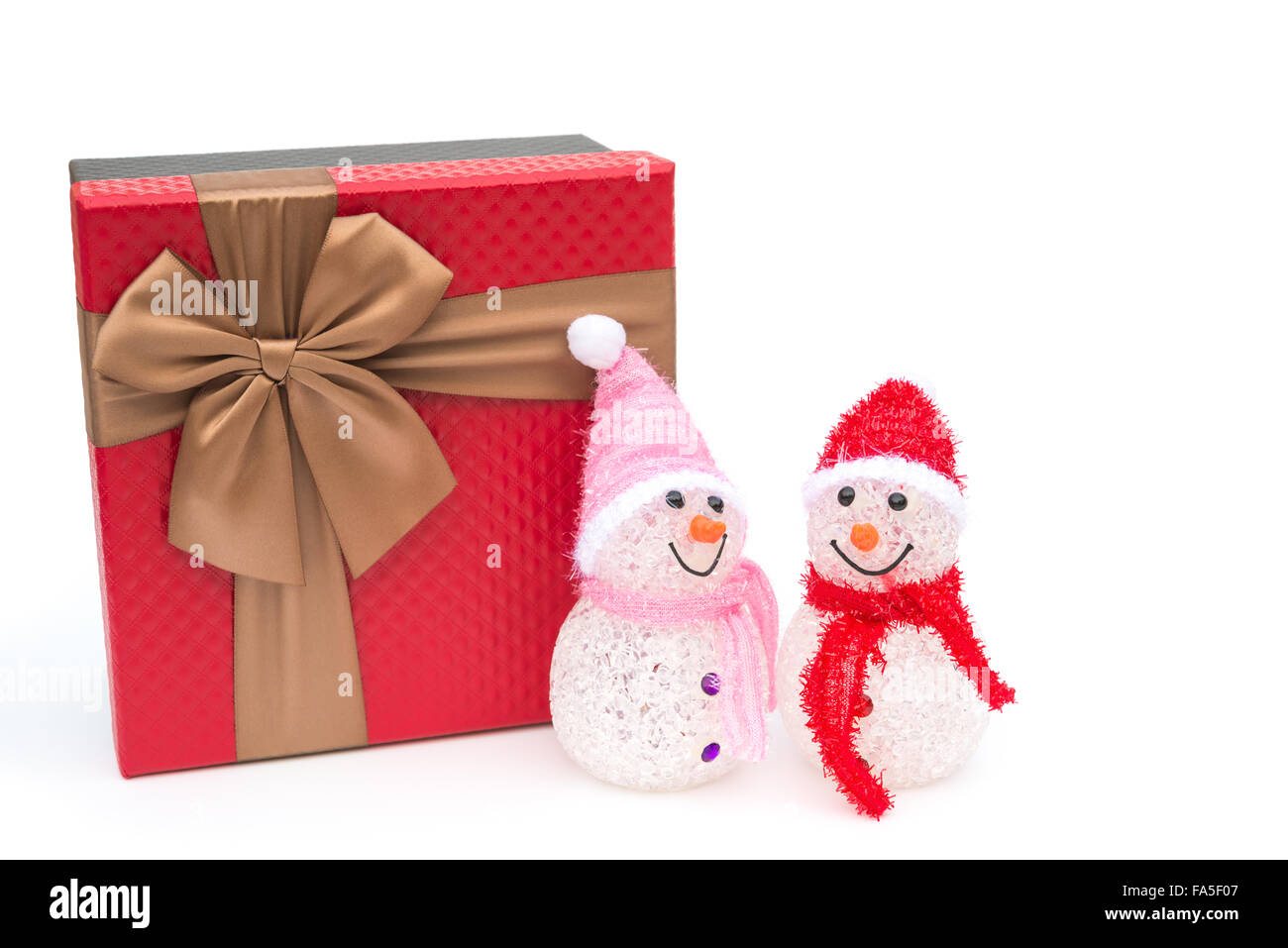 zwei lächelnde Spielzeug Weihnachten Schneemann und eine Geschenkbox auf weißem Hintergrund Stockfoto