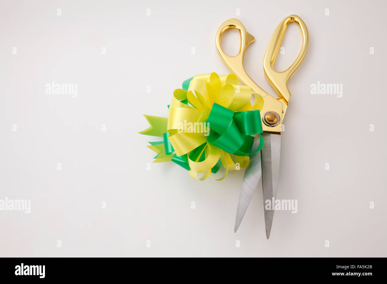 grün gelbes Band Bögen und Schere Stockfoto