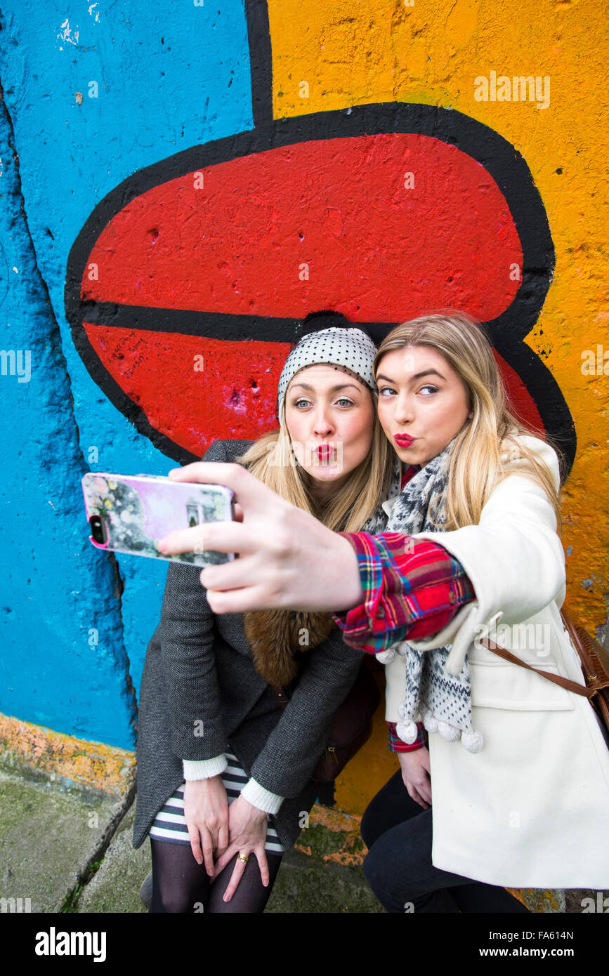 Mädchen nehmen eine Selfie am Teil der Berliner Mauer Deutschland Stockfoto