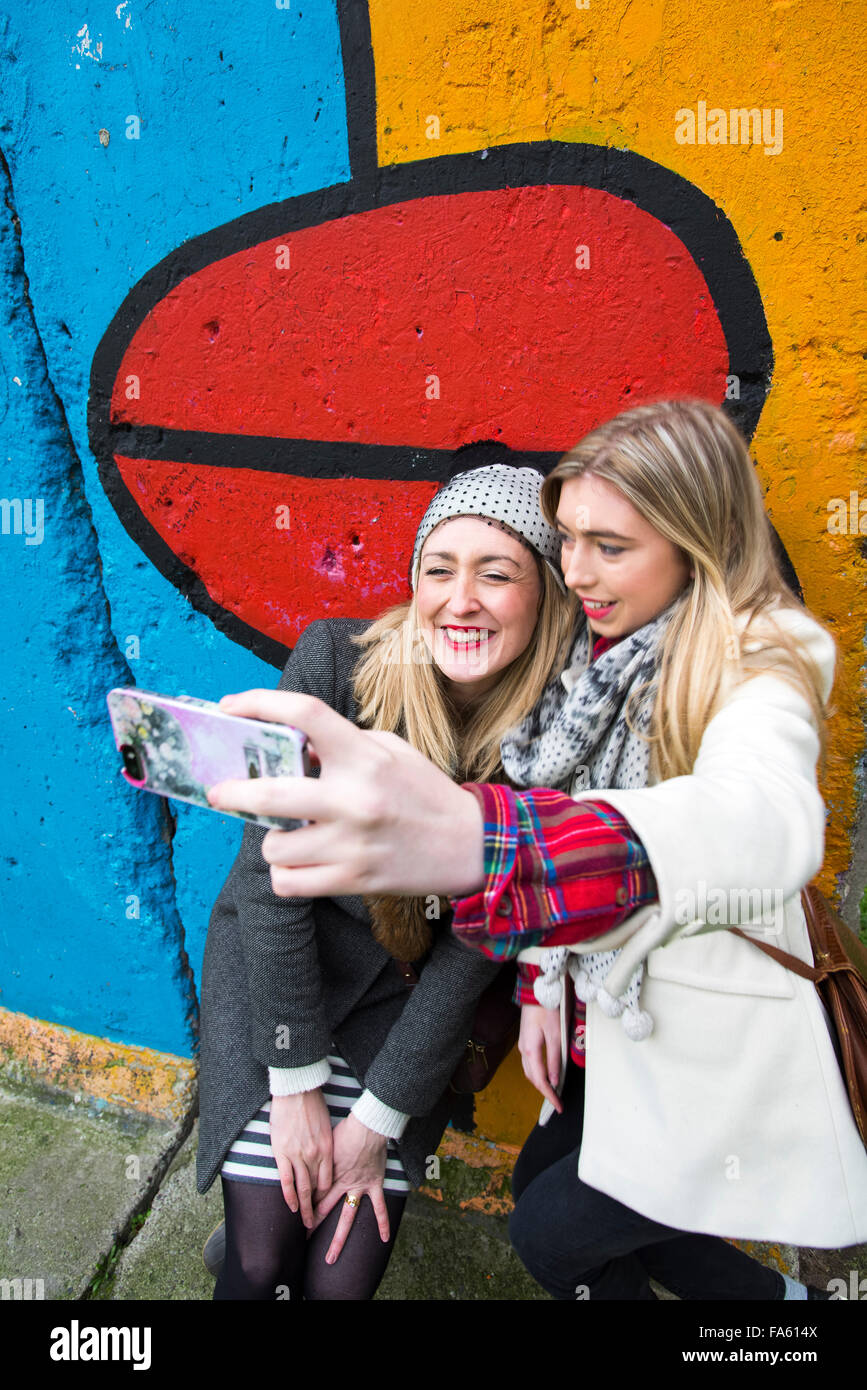 Mädchen nehmen eine Selfie am Teil der Berliner Mauer Deutschland Stockfoto