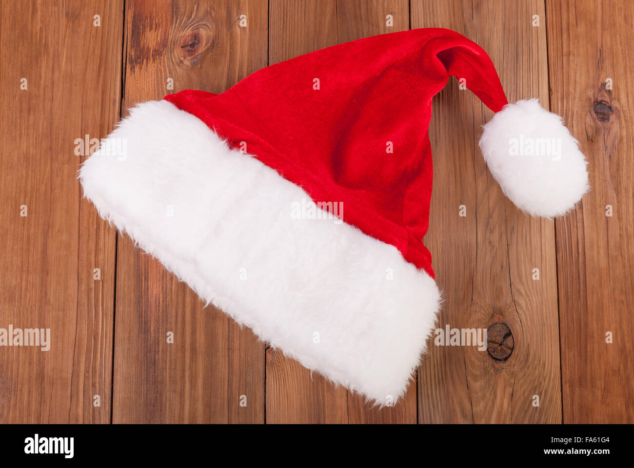 Weihnachtsmütze auf einem hölzernen Hintergrund. Stockfoto