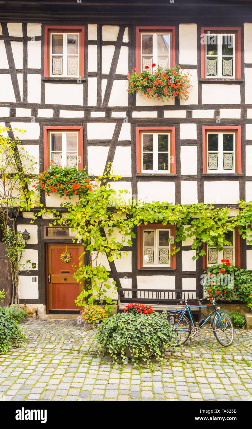 Fahrrad vor der Flowerdecked Fassade halb Fachwerkhaus in der Altstadt von Esslingen, Baden-Württemberg Stockfoto