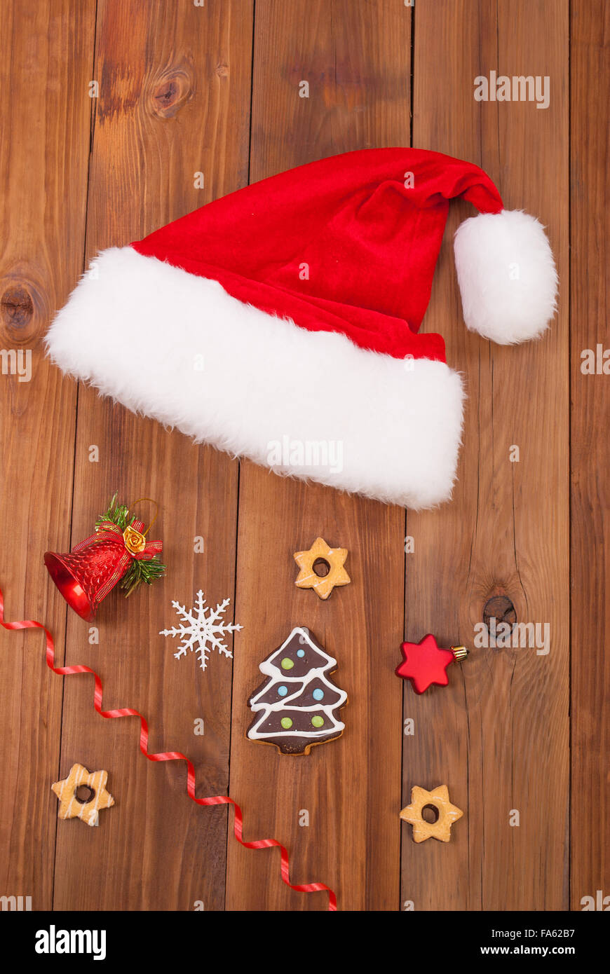 Hut von Weihnachtsmann und Weihnachten Kugeln auf Holztisch. Stockfoto