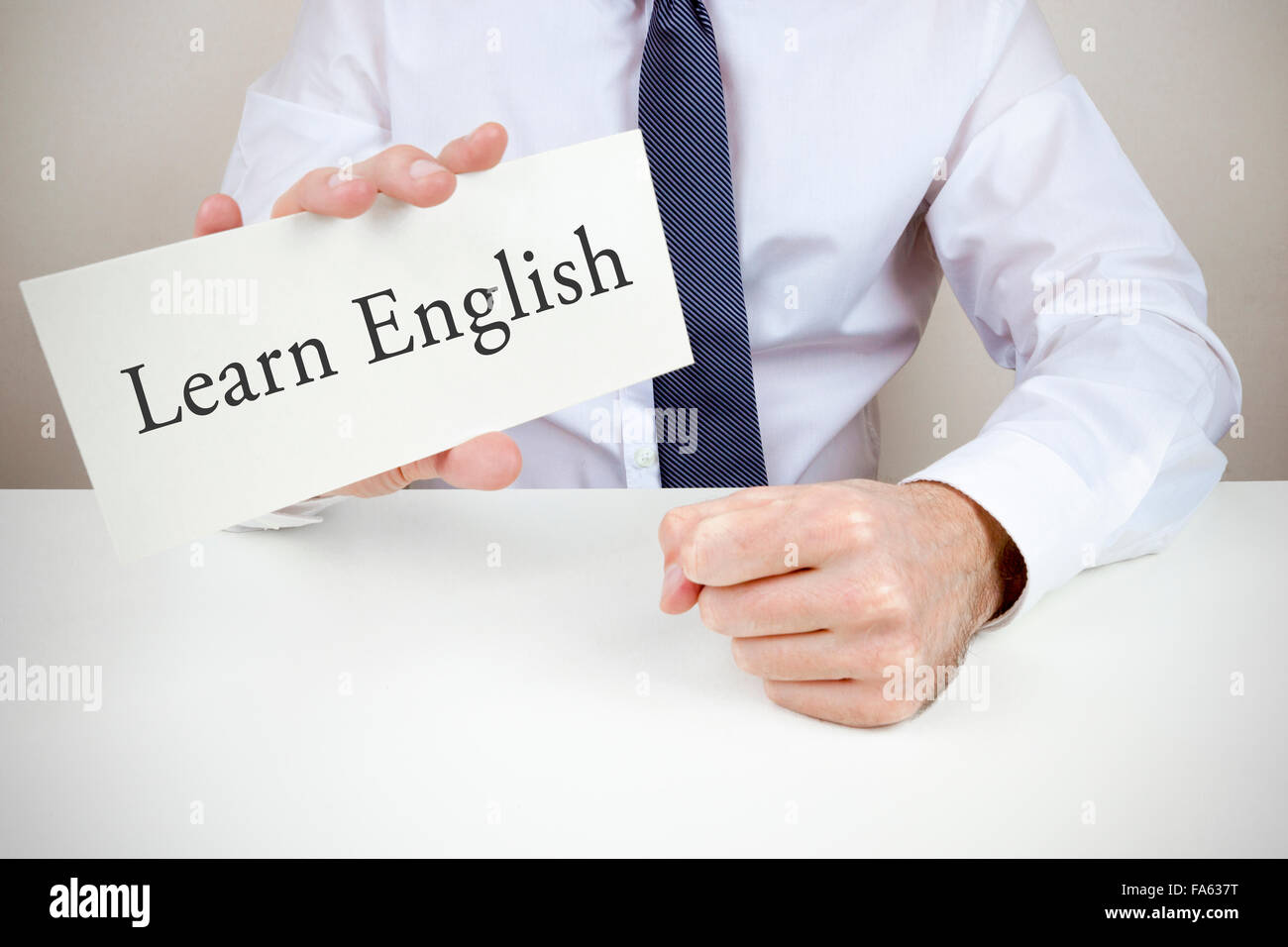 Ein Mann gekleidet in Hemd und Krawatte hält eine Karte, um Englisch zu  lernen Stockfotografie - Alamy