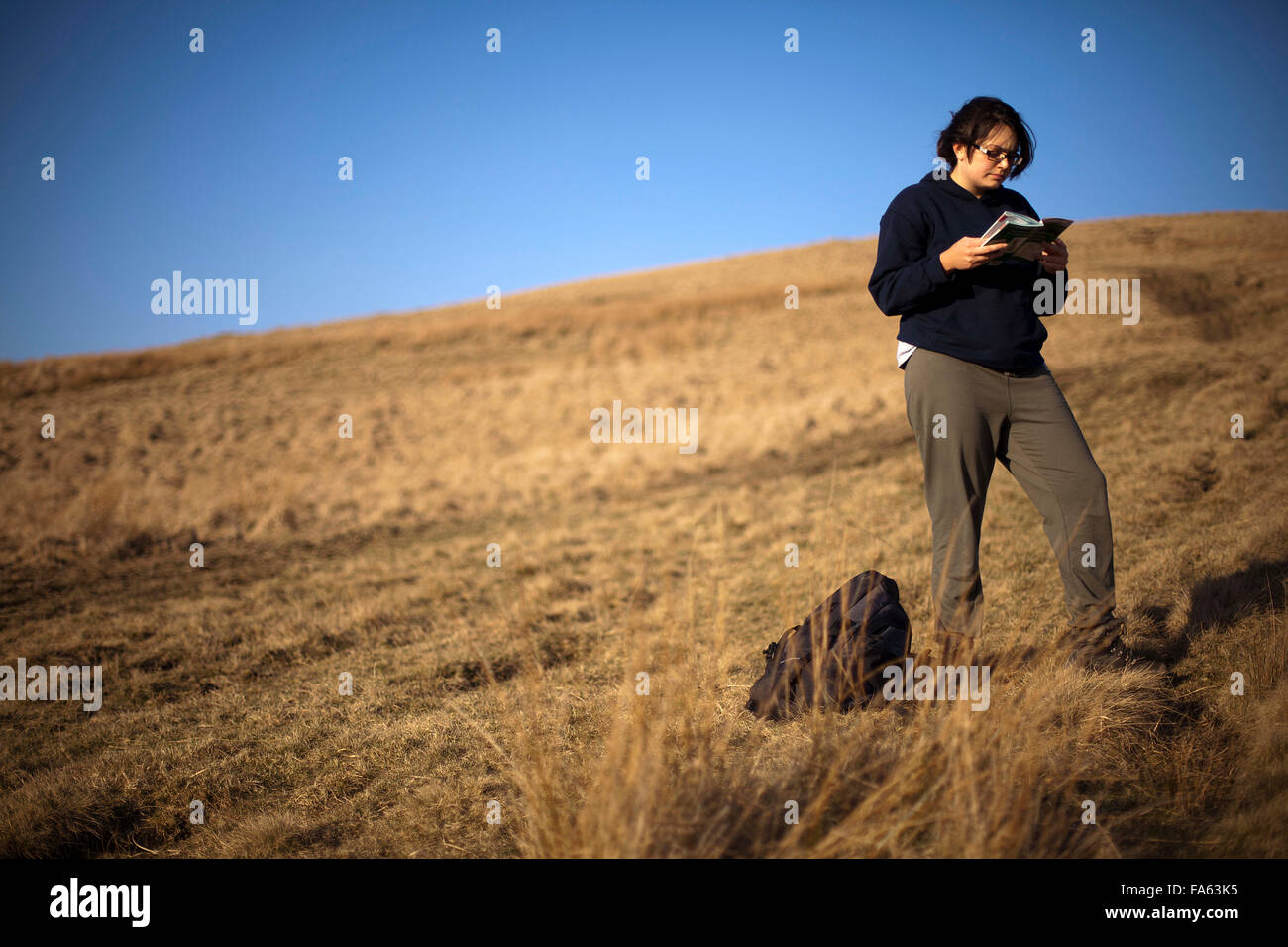 Eine Frau liest ein Ratgeber während auf einem Spaziergang Stockfoto