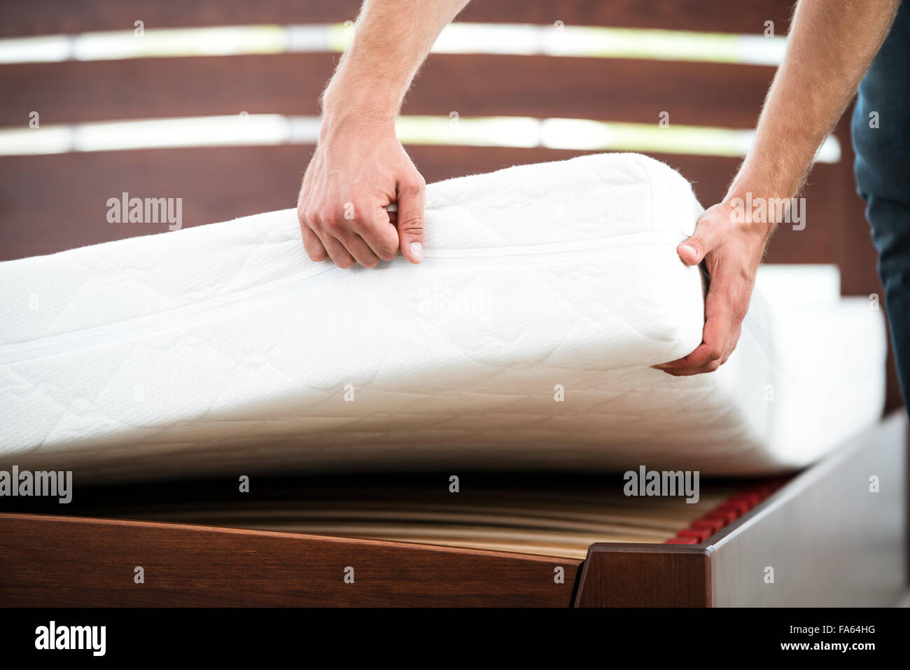 Junger Mann in der Nähe von weißen Bett Stockfoto