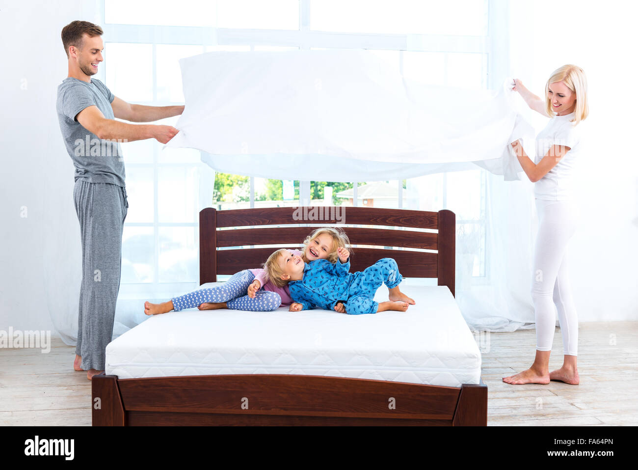 Junge nette Familie Bett machen Stockfoto