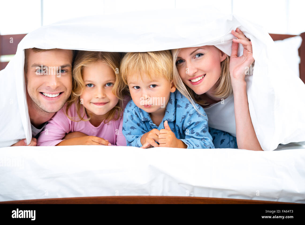 Junge Familie auf weißen Bett Stockfoto