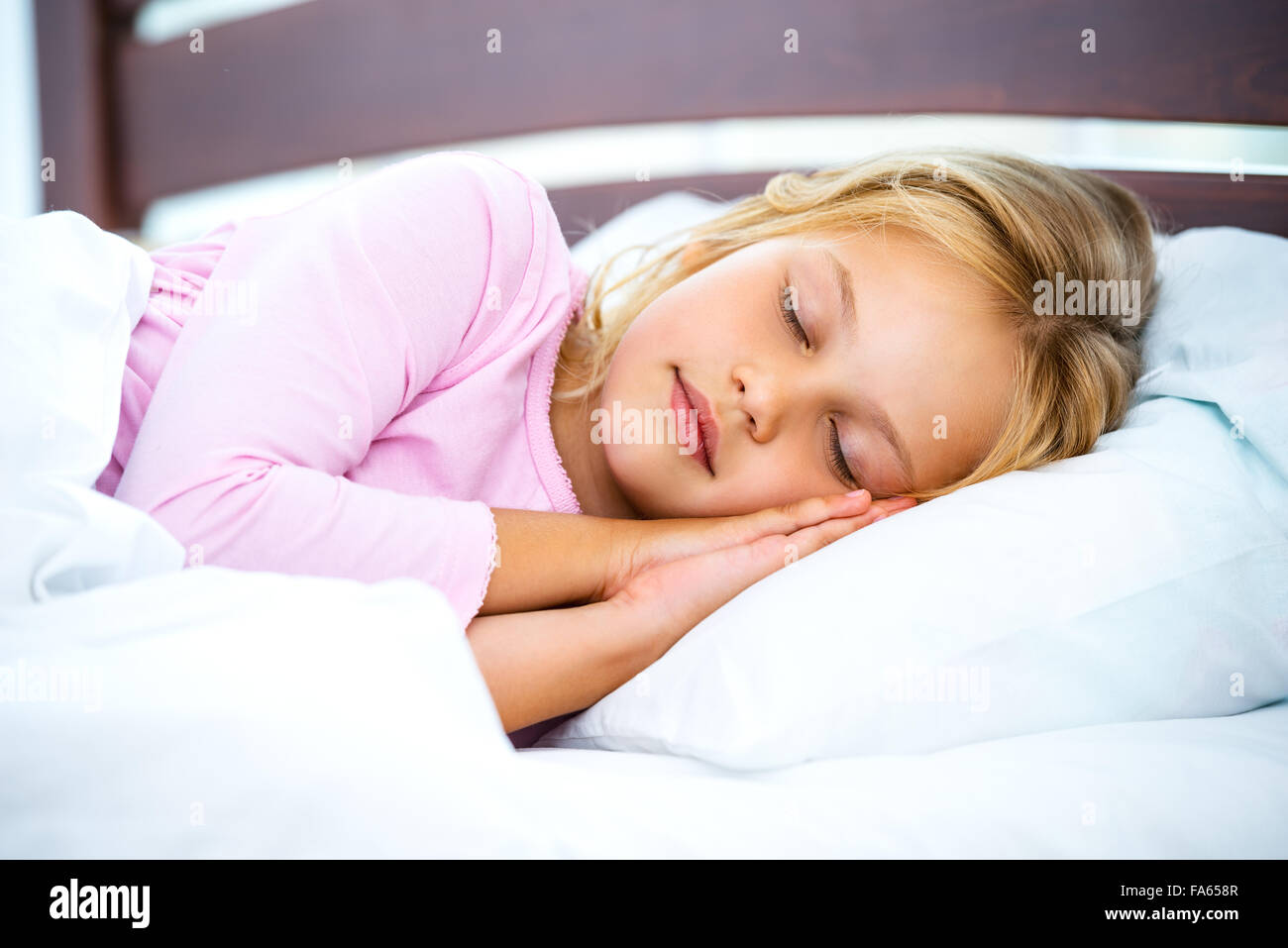 Kleines Mädchen auf weißen Bett schlafen Stockfoto