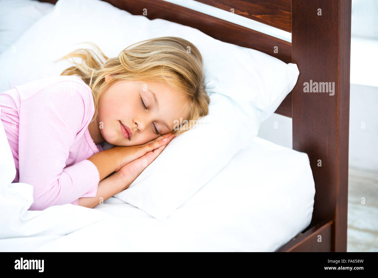 Kleines Mädchen auf weißen Bett schlafen Stockfoto