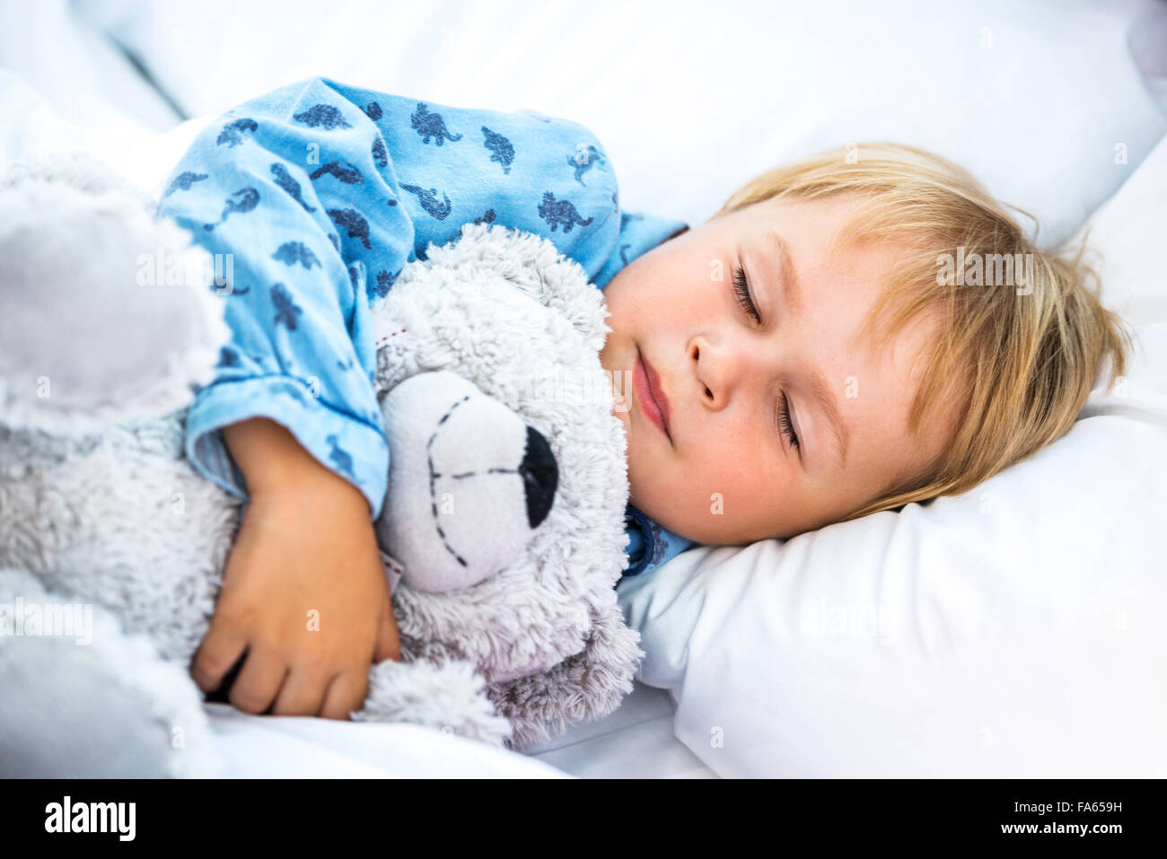 Kleiner Junge auf weißen Bett schlafen Stockfoto