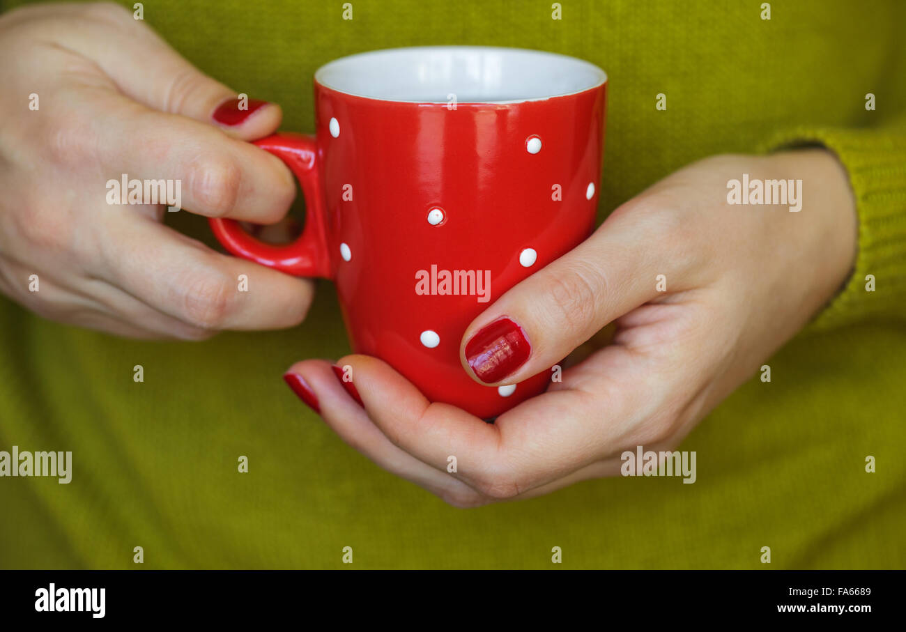 Frau Hände halten einen gemütlichen roten Becher. Winter und Weihnachten-Zeit-Konzept Stockfoto