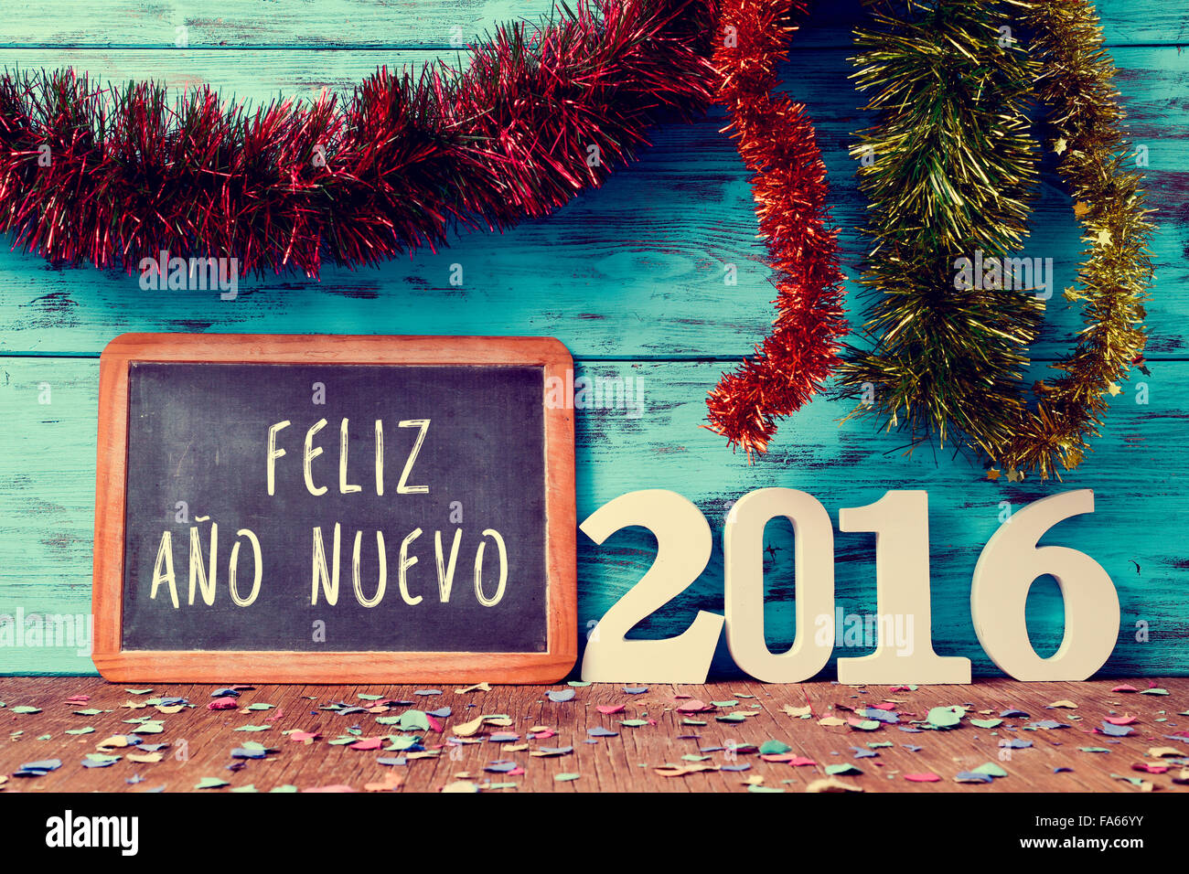 Lametta in verschiedenen Farben und eine Tafel mit dem Text Feliz Ano Nuevo, happy New Year auf Spanisch und weiße Zahlen bilden Stockfoto