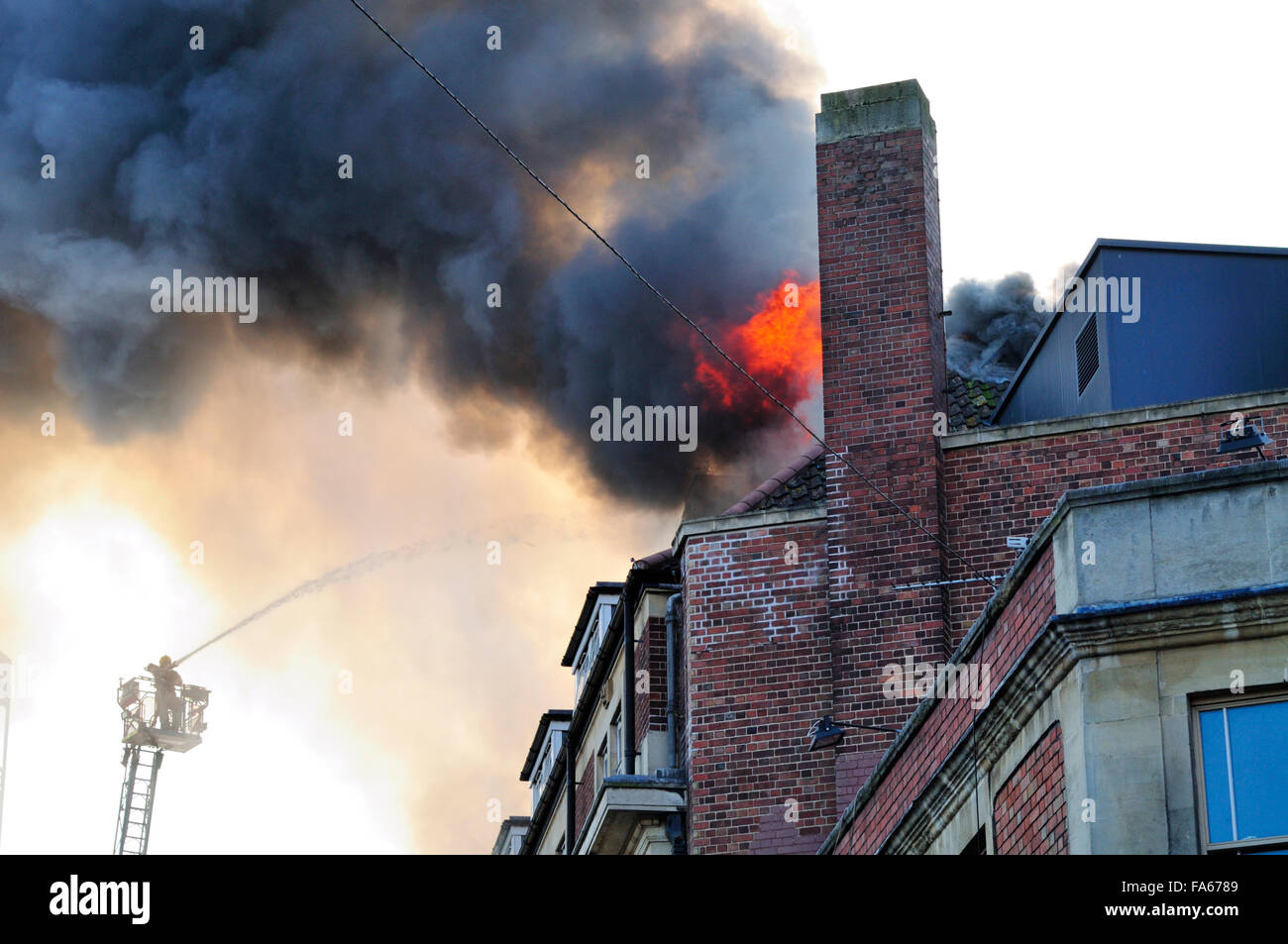Hochhaus-Brand mit starken schwarzen Rauch und Leiter Motor Besprühen mit Wasser Stockfoto
