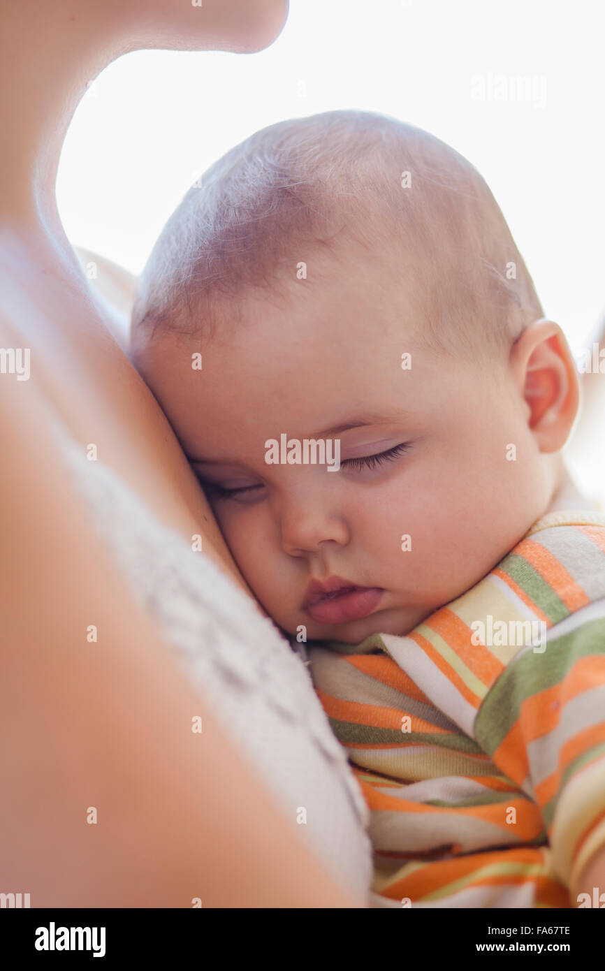 Babymädchen schlafen in den Armen der Mutter Stockfoto