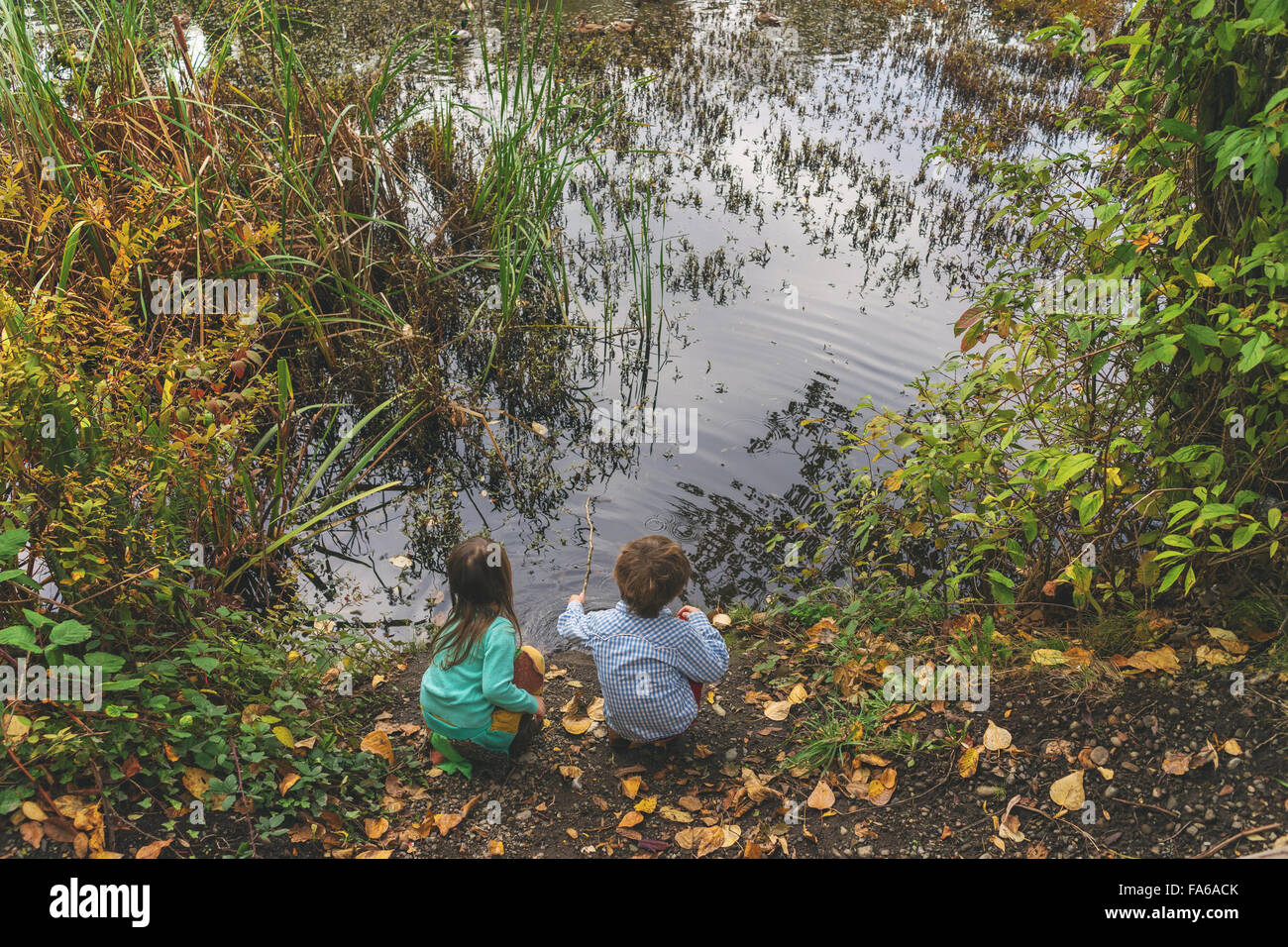 Erhöhten Blick auf jungen und Mädchen sitzen an einem See Stockfoto