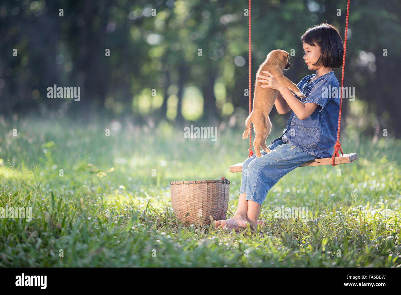 Mädchen auf Seil Schaukel mit ihrem Hund Stockfoto