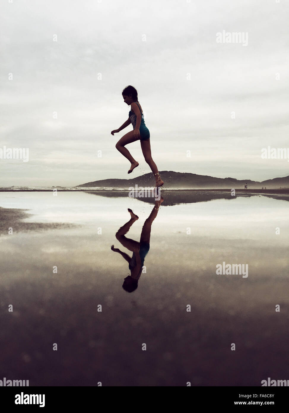 Spiegelt sich die Silhouette von Mädchen am Strand laufen Stockfoto