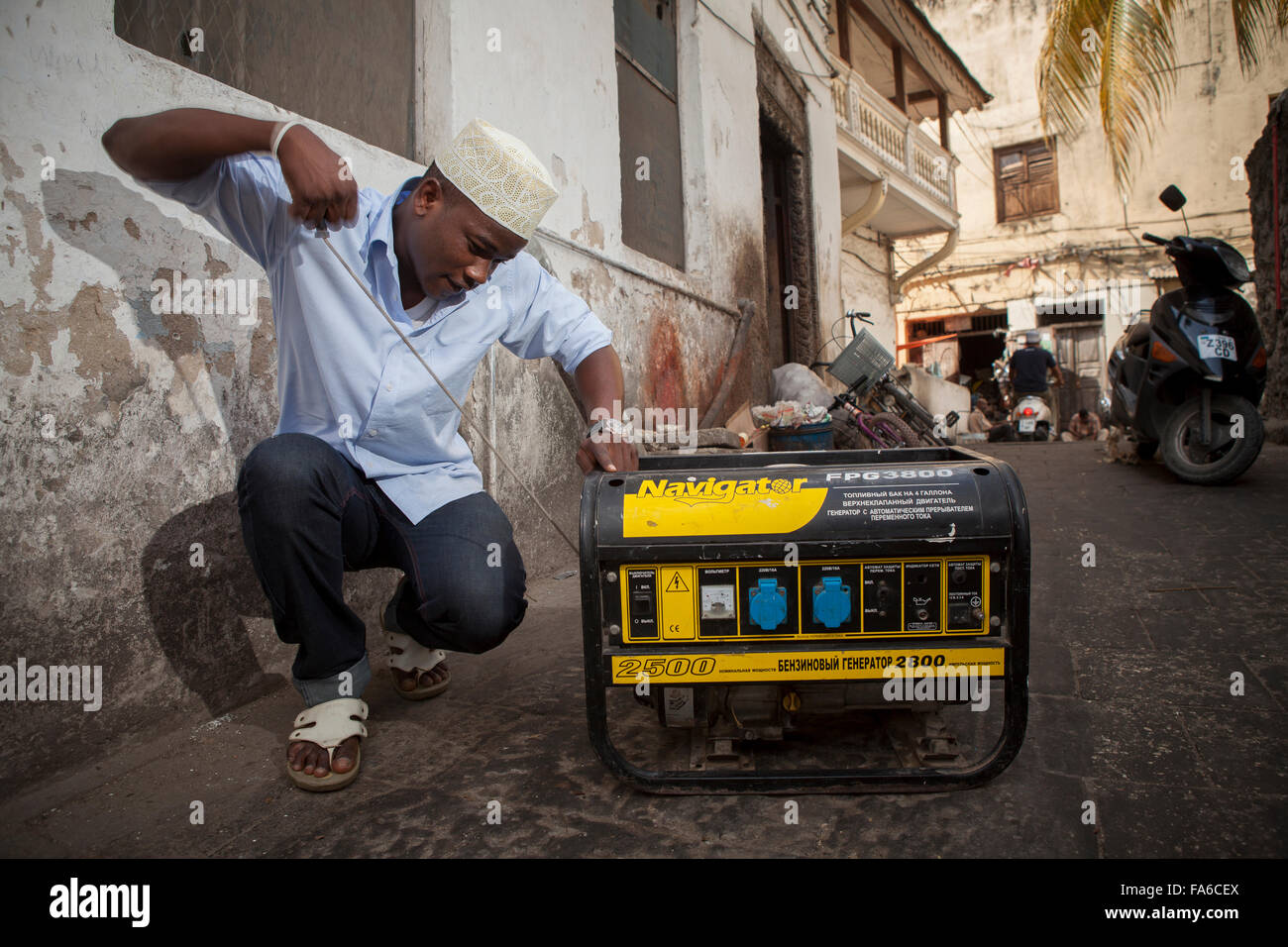 Restaurant-Besitzer Hamisi Saleh Lukmaan startet einen Generator bei einem Stromausfall in Stonetown, Zanzibar, E. Afrika. Stockfoto