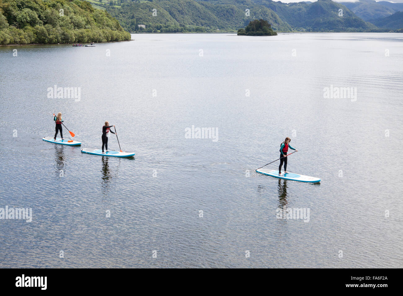Drei junge Frauen Paddle Boarding auf Derwentwater im Lake District Stockfoto