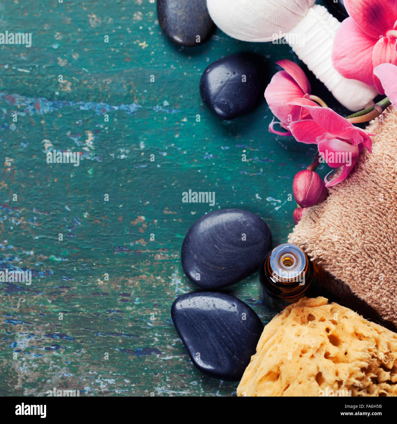 Spa-Hintergrund (rosa Orchidee, pflanzliche Kompresse Briefmarken, Meersalz, Handtuch- und massage-Steinen) Stockfoto