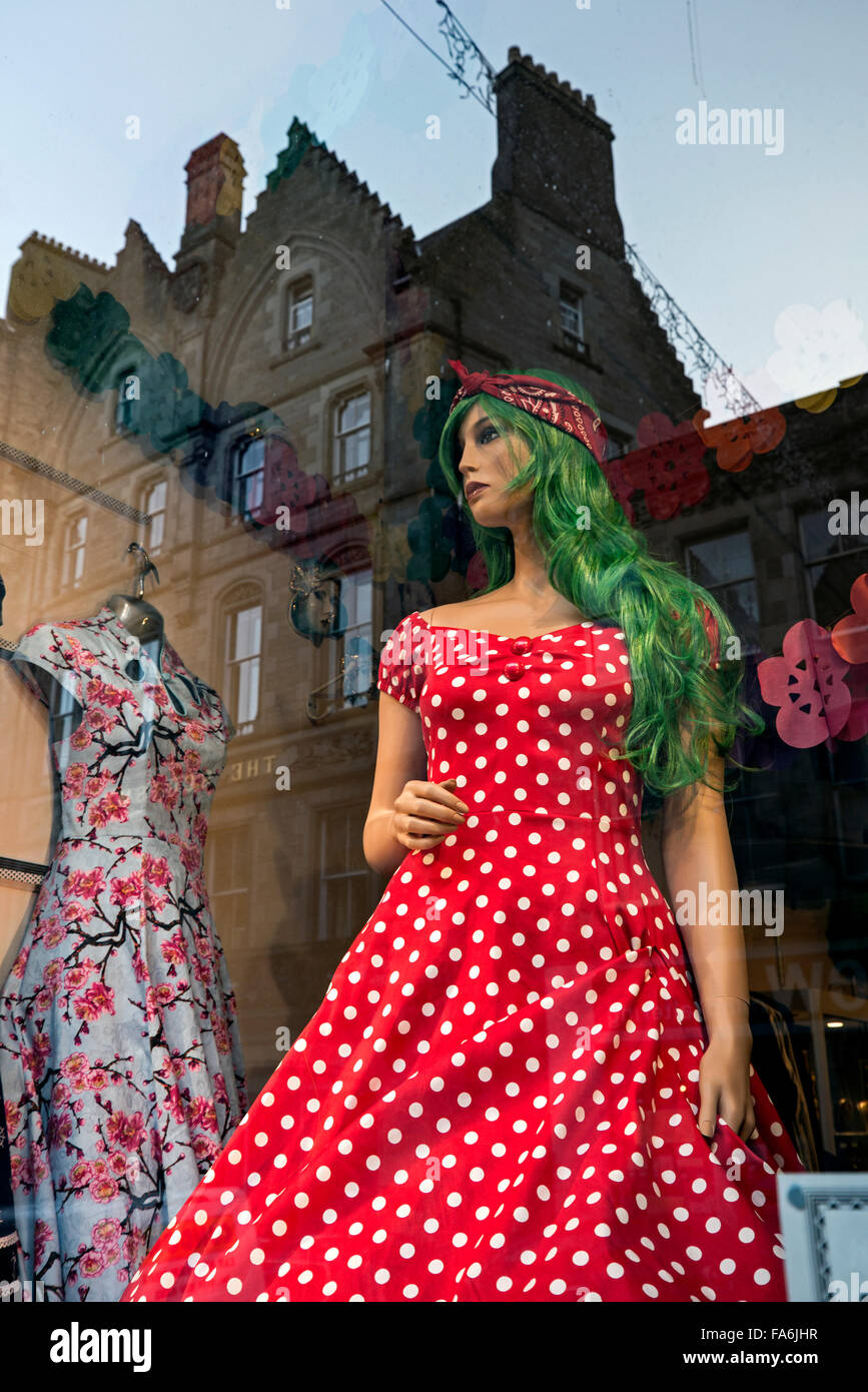 Mannequin mit grünen Haaren, gekleidet in einen roten gepunkteten Kleid in einem Schaufenster in Cockburn Street, Edinburgh, Schottland, UK Stockfoto