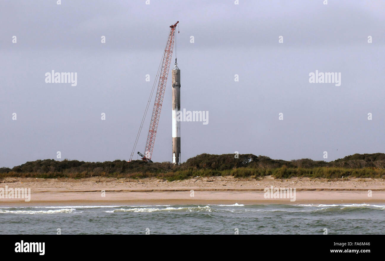 Cape Canaveral, Florida, USA. 22. Dezember 2015. Ein Kran ist gesehen heben die erste Stufe einer SpaceX Falcon 9 Rakete am Morgen, nachdem es 11 ORBCOMM-Kommunikations-Satelliten in die Erdumlaufbahn gestartet, vor der Landung erfolgreich zurück auf Cape Canaveral Air Force Station etwa zehn Minuten später 21. Dezember 2015. Dies ist das erste Mal, das SpaceX eines seiner Raketen an Land gelandet ist. Die historische Leistung stellt einen bedeutenden Schritt in der Technologie der wiederverwendbaren Raketen. Bildnachweis: Paul Hennessy/Alamy Live-Nachrichten Stockfoto