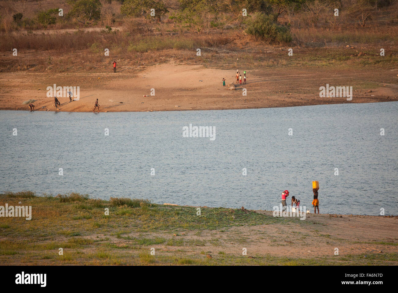 Einwohner ziehen Wasser aus dem Muecula-Fluss in der Nähe von Nacala Dam und Reservoir in Provinz Nampula, Mosambik. Stockfoto