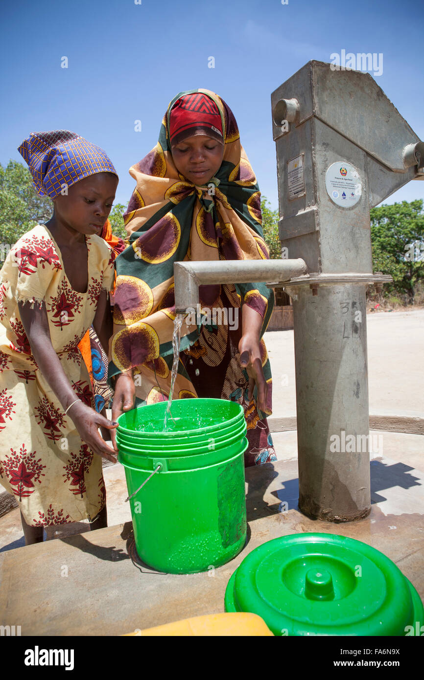 Kinder malen sauberes Wasser aus dem Bohrloch in Mecupes Dorf, Norden Mosambiks. Stockfoto