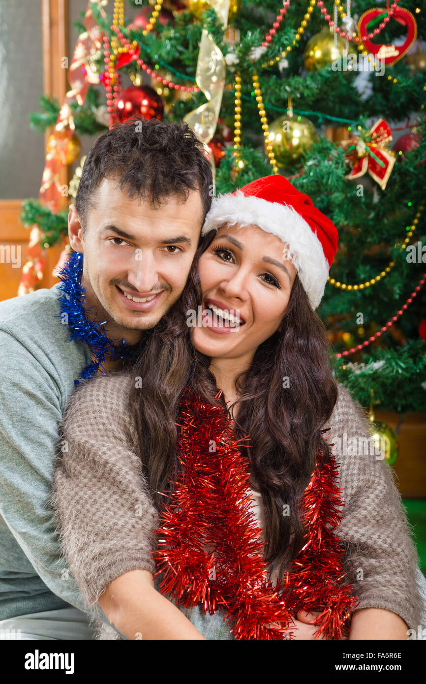 Mann und Frau zu Weihnachten Austausch von Liebe und Glück, schönes paar von Xmas Baum lächelnd mit dem Ausdruck ihrer schönen Urlaubsgefühle Stockfoto