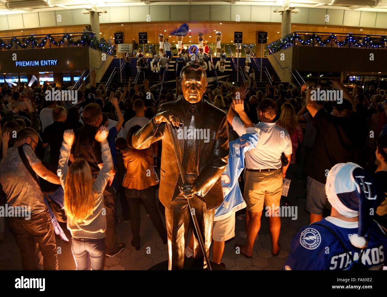 Tampa, Florida, USA. 22. Dezember 2015. DOUGLAS R. CLIFFORD | Times.Fans Pass die beleuchtete Phil Esposito-Statue als die Blitz-Mädchen, Hintergrund, öffnen ihre Pforten für Dienstag (22.12.15) Spiel zwischen den Tampa Bay Lightning und die Vancouver Canucks in der Amalie Arena in Tampa. Die Festschrift Bronze entstand zu Ehren des NHL-Hall-of-Fame Phil Esposito für seine Rolle in der Mitgründung der Tampa Bay Lightning-Franchise und wurde im Jahr 2011 vorgestellt. © Douglas R. Clifford/Tampa Bucht Mal / ZUMA Draht/Alamy Live News Stockfoto