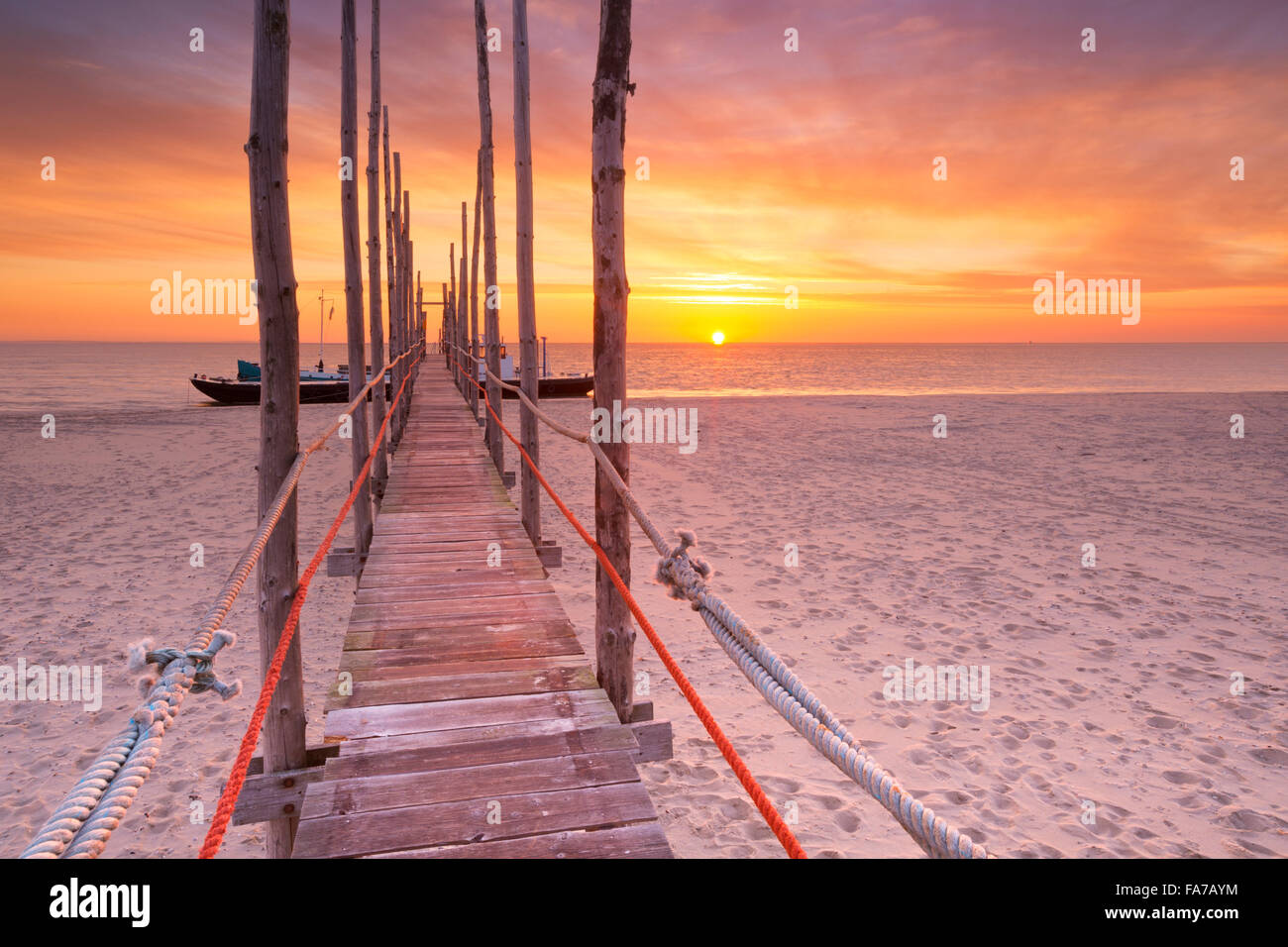Spektakulären Sonnenaufgang Farben über einen Steg am Strand auf der Insel Texel in den Niederlanden. Stockfoto
