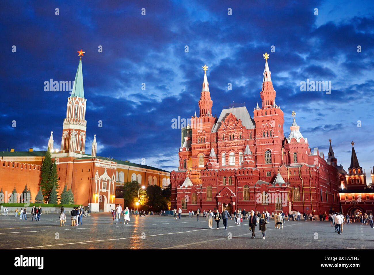 Menschen, die in der Abenddämmerung auf dem Roten Platz vor dem State Historical Museum spazieren gehen. Moskau, Russland. Stockfoto