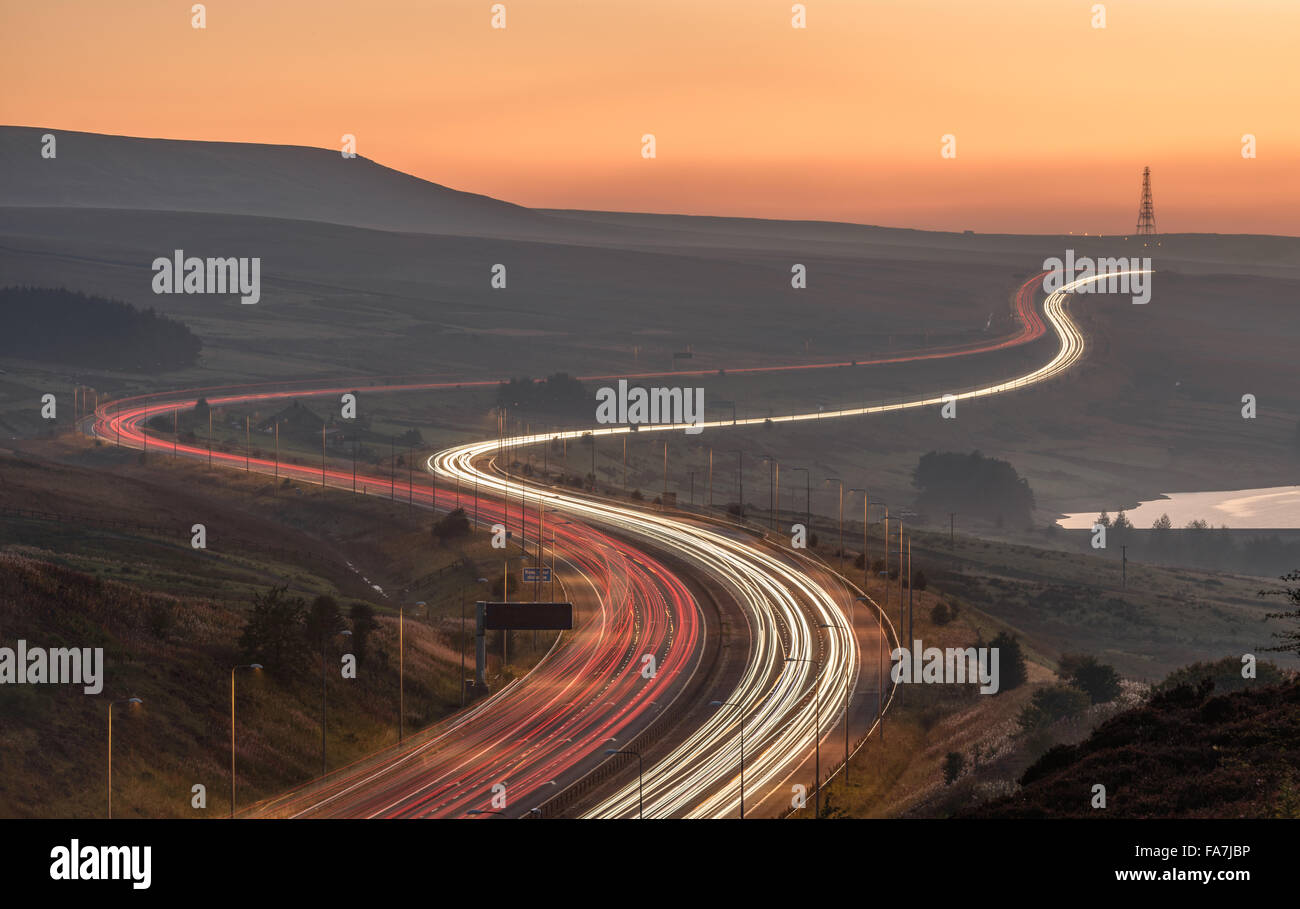 Autobahn M62 weben durch die Pennines mit Langzeitbelichtung Lichtspuren. Windy Hill Mast in der Ferne. Stockfoto