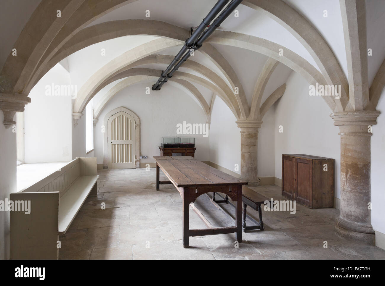 Die Diener Halle mit der viktorianischen Heizungsrohre, die entlang der Decke in Lacock Abbey, Wiltshire. Stockfoto