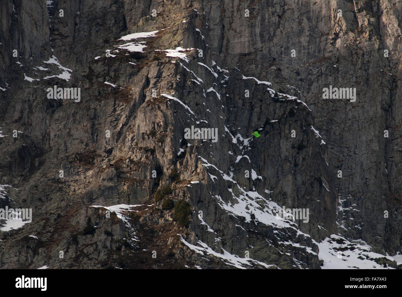 Wingsuit-Flyer gleiten hinunter das Gesicht eines Berges Stockfoto