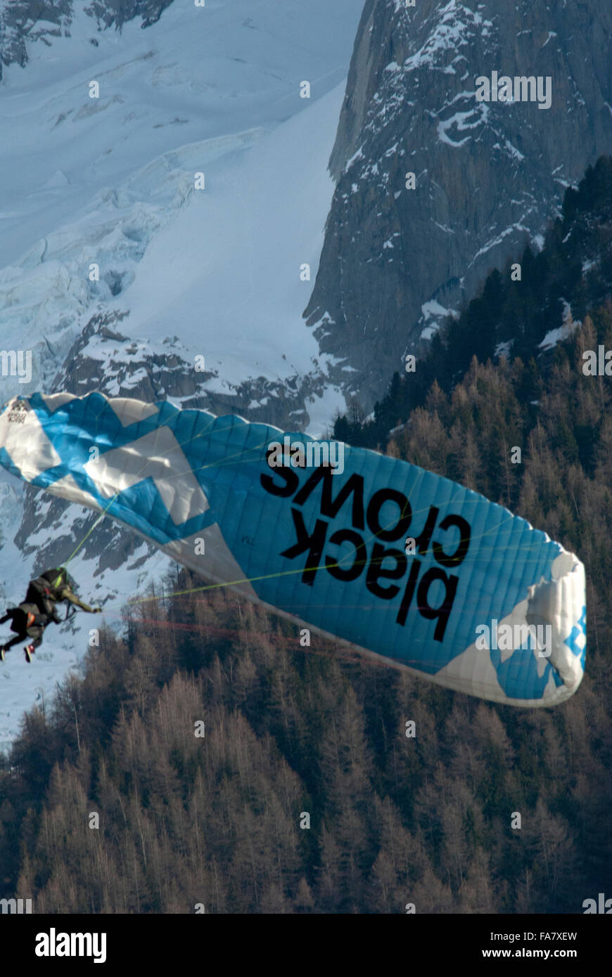 Tandempilot Paragliding geben sein Beifahrer einen Nervenkitzel durch Ausführen eines teilweisen Flügels über vor Gletscher und Wald. Stockfoto