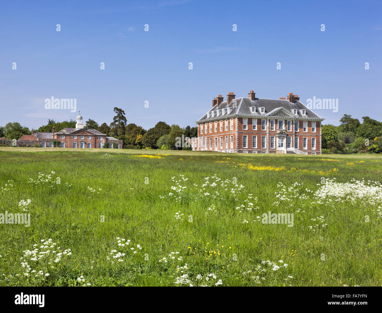 Südfront des Hauses von der Wiese mit weißen Blüten in Uppark House and Garden, West Sussex. Stockfoto