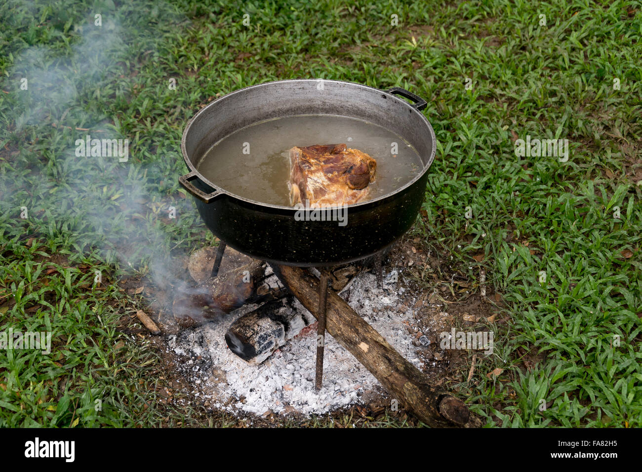 Weihnachtsschinken im Freien in einem Kohle-Topf gekocht wird. Stockfoto