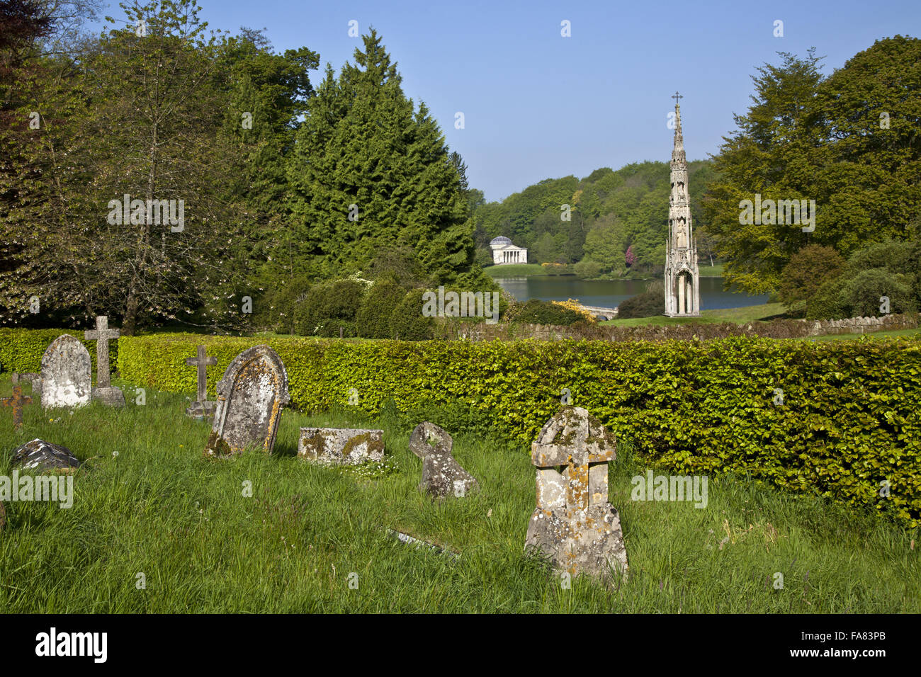 Der Blick aus dem Kirchhof von St. Peter ist gegenüber dem Bristol hohe Kreuz und das Pantheon über bei Stourhead, Wiltshire. Stockfoto