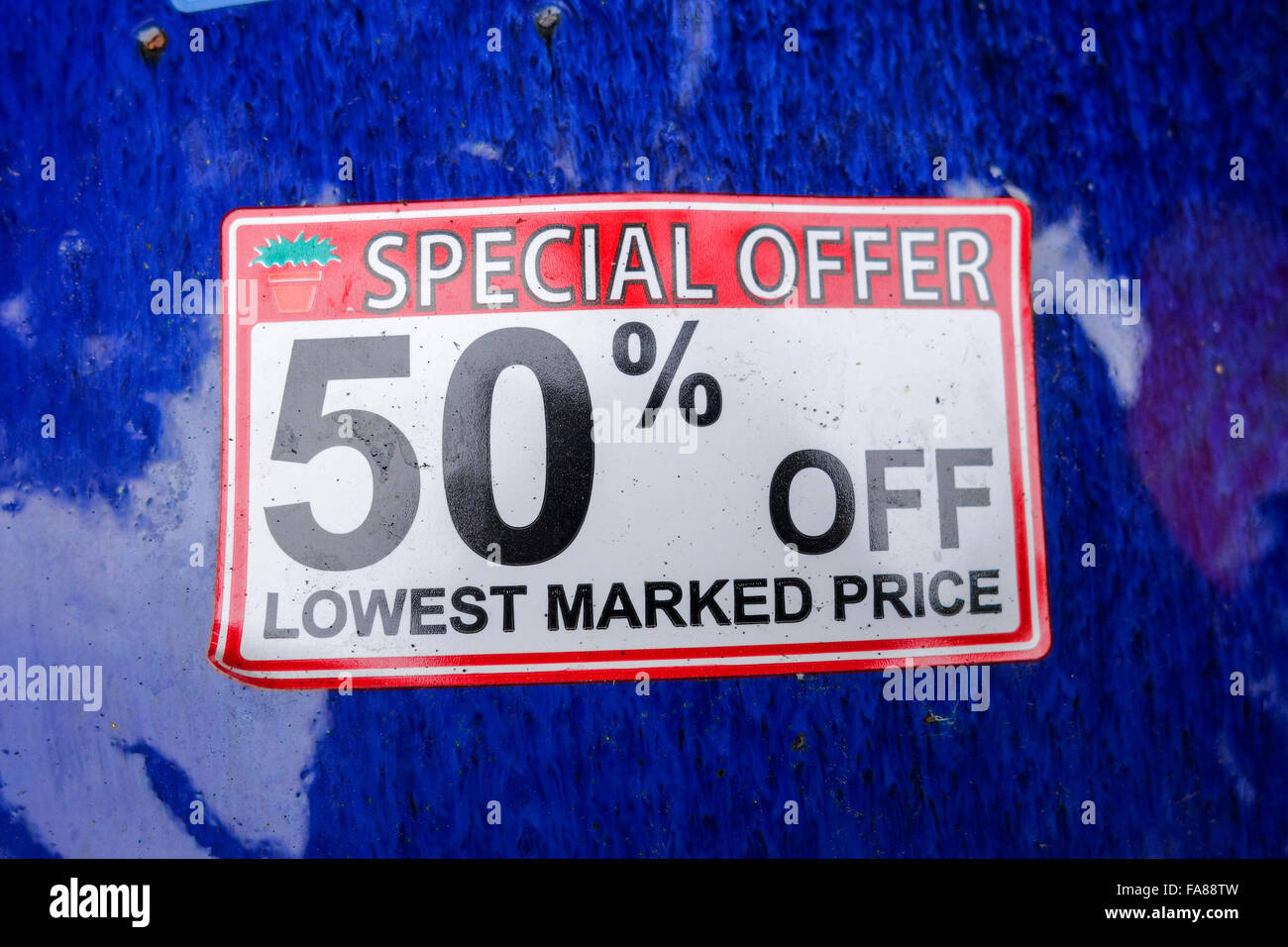 Ein 50 % Rabatt auf niedrigsten Preis Spezialangebot Aufkleber auf einer blauen glänzenden Oberfläche Stockfoto