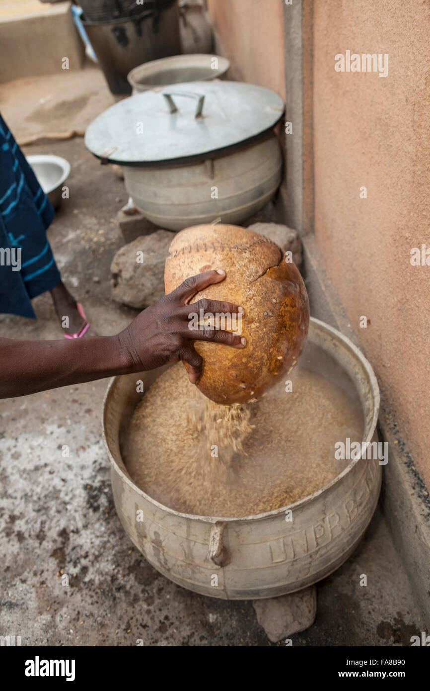 Reis ist parboiled, vor dem Verkauf an eine Gruppe Verarbeitung Frauenzentrum in Sourou Provinz, Burkina Faso. Stockfoto
