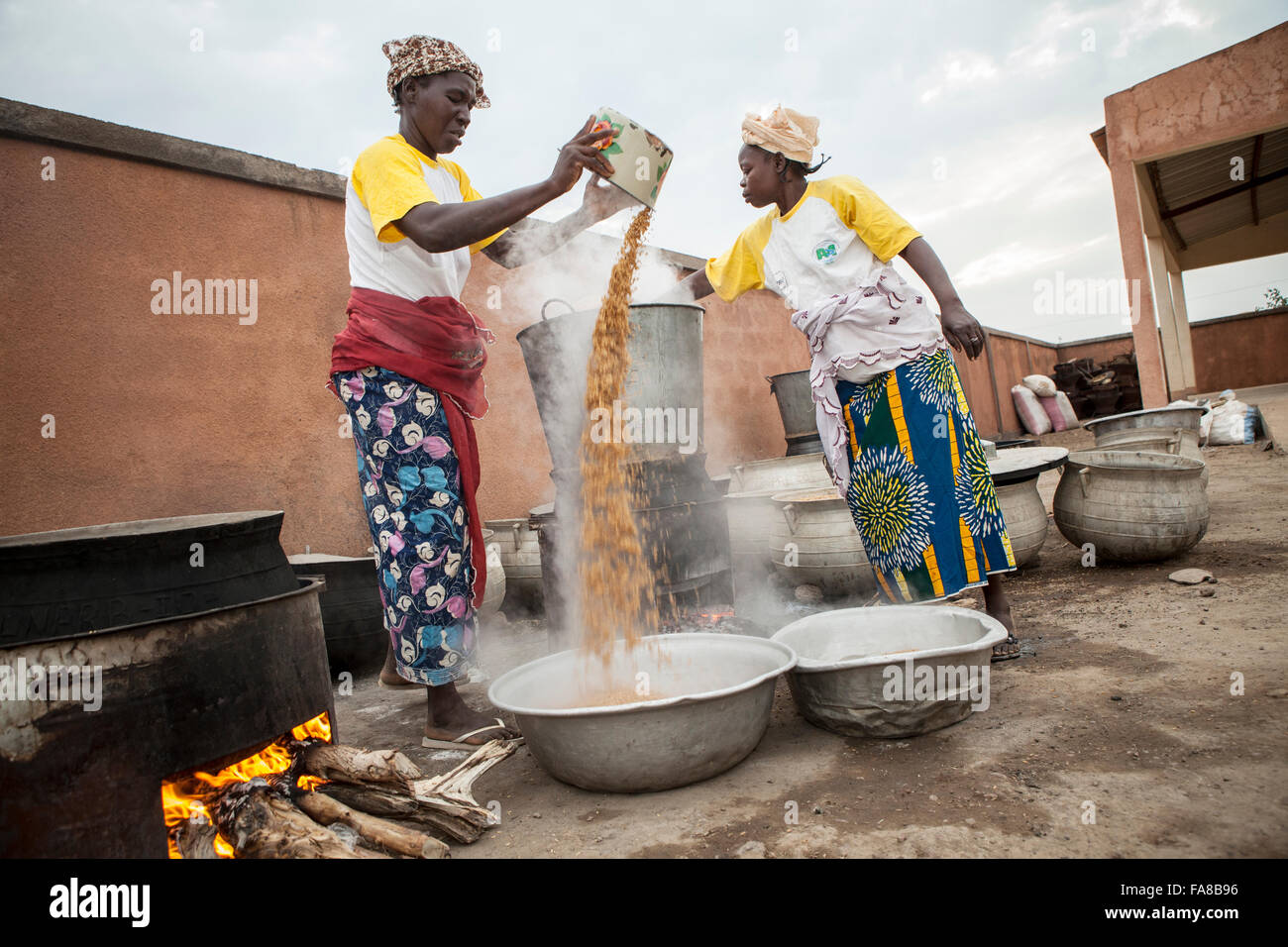 Reis ist parboiled, vor dem Verkauf an eine Gruppe Verarbeitung Frauenzentrum in Sourou Provinz, Burkina Faso. Stockfoto
